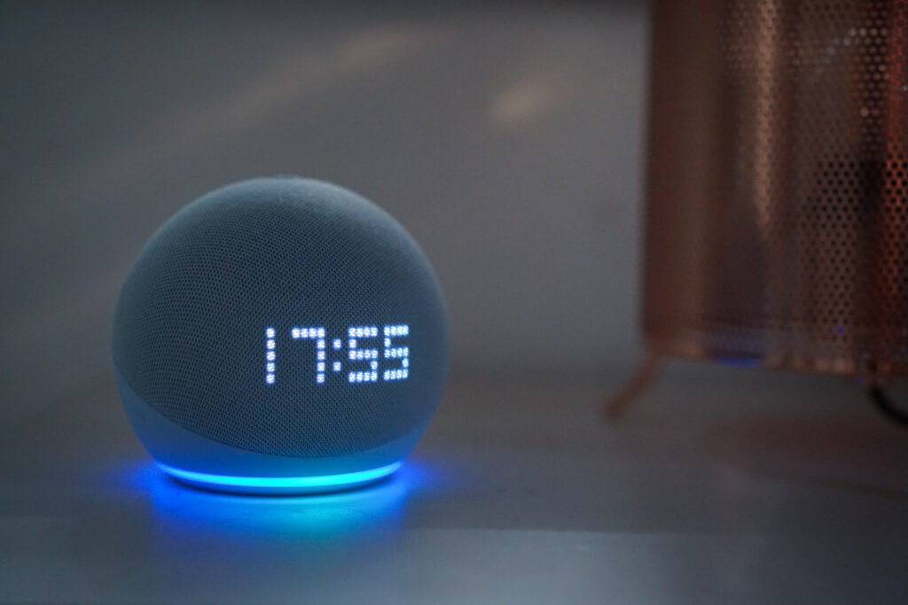 Ein runder, leuchtender Smart Speaker zeigt die Uhrzeit 17:55 an.