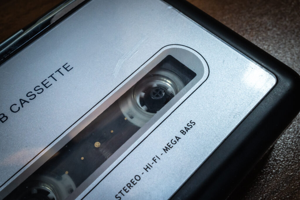 Nahaufnahme eines silberfarbenen, tragbaren Kassettenrekorders mit eingelegter Audiokassette.