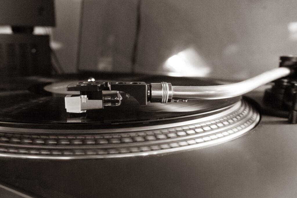 Plattenspieler in Nahaufnahme: Der Tonarm liegt auf einer schwarzen Vinylschallplatte.